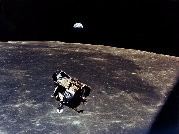 Apollo 10's lunar module "Snoopy" above the moon's surface, with Earth rising in the background